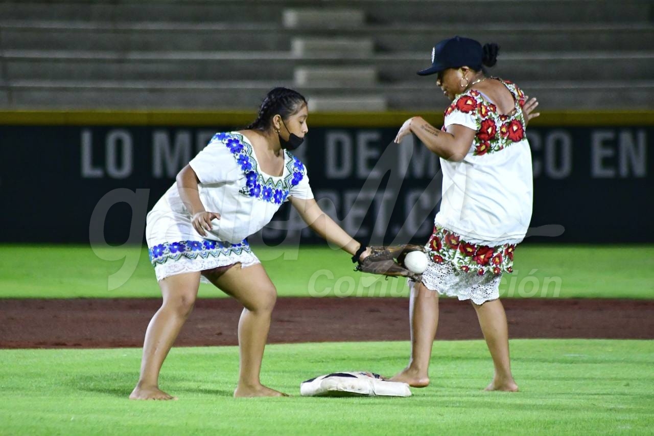 Cancún, 18 de noviembre (Infoqroo).- Las Diablillas de Hodzonot superaron 16-15 a las Amazonas de Yaxunah, en histórico duelo de softbol femenil que se definió en episodios extras celebrado esta noche en el renovado parque de pelota “Beto Ávila” de Cancún. El estadio Beto Ávila recibió a una gran cantidad de aficionados que disfrutaron a estos peculiares equipos jugar softbol con huipil y sin zapatos, vio la presentación de ambos rosters, una por una, luego de un pequeño retraso debido a unas pequeñas complicaciones con la llegada de las yucatecas. Una vez en el juego, las Amazonas atacaron primero al ponerse al frente en la pizarra con par de carreras en los pies de Flor Moo y Berenice Ayy. En el segundo y tercer acto, de nueva cuenta las yucatecas sumaron en el marcador al anotar una carrera por entrada y poner las cosas cuatro carreras por cero. Sin embargo, las Diablillas le pusieron cifra a su casillero en la parte baja del tercer episodio con carrera anotada por Luciana Uh quien abrió con sencillo, se robó par de colchonetas y anotó gracias a batazo de Yaneli May. Para el quinto rollo, las cosas se pusieron cuesta arriba para las quintanarroenses, pues cuatro carreras en su contra pusieron la pizarra diez por cinco; más nunca dejaron de luchar y para el séptimo inning llegaron empatadas gracias a cinco carreras anotadas en la baja de la sexta. El encuentro se definió en entradas extras pues ambas novenas anotaron par de carreras en la séptima y la pizarra era 12-12. El octavo capítulo llegó y en común acuerdo el inning inició con corredora en segunda, dando tres picotazos en la parte alta las amazonas, teniendo un cierre de película la parte baja, con cuatro carreras anotadas para las locales, dejando en el terreno a su rival y quedándose así con la victoria.
