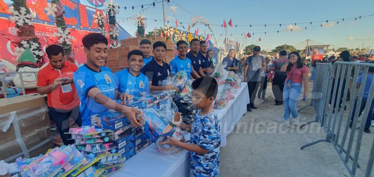 Jugadores del Inter Playa reparten juguetes a niñas y niños asistentes al Recinto Ferial de Solidaridad